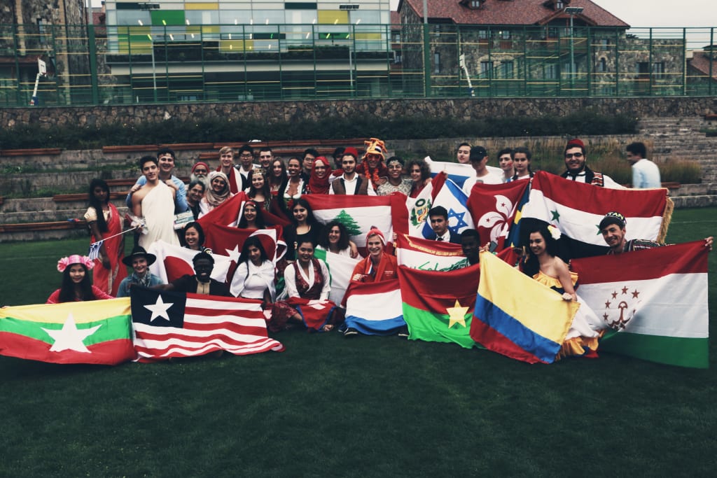 Collection of UWC students holding up their countries flags